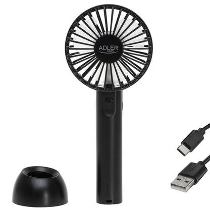 Ein schwarzer Mini-Handventilator AD 7338 von immer-saugut mit einer runden „ADLER“-Lüftungsöffnung und einem zylindrischen Griff wird zusammen mit einer schwarzen Ladestation und einem akkufreundlichen USB-A-zu-USB-C-Kabel auf weißem Hintergrund abgebildet.
