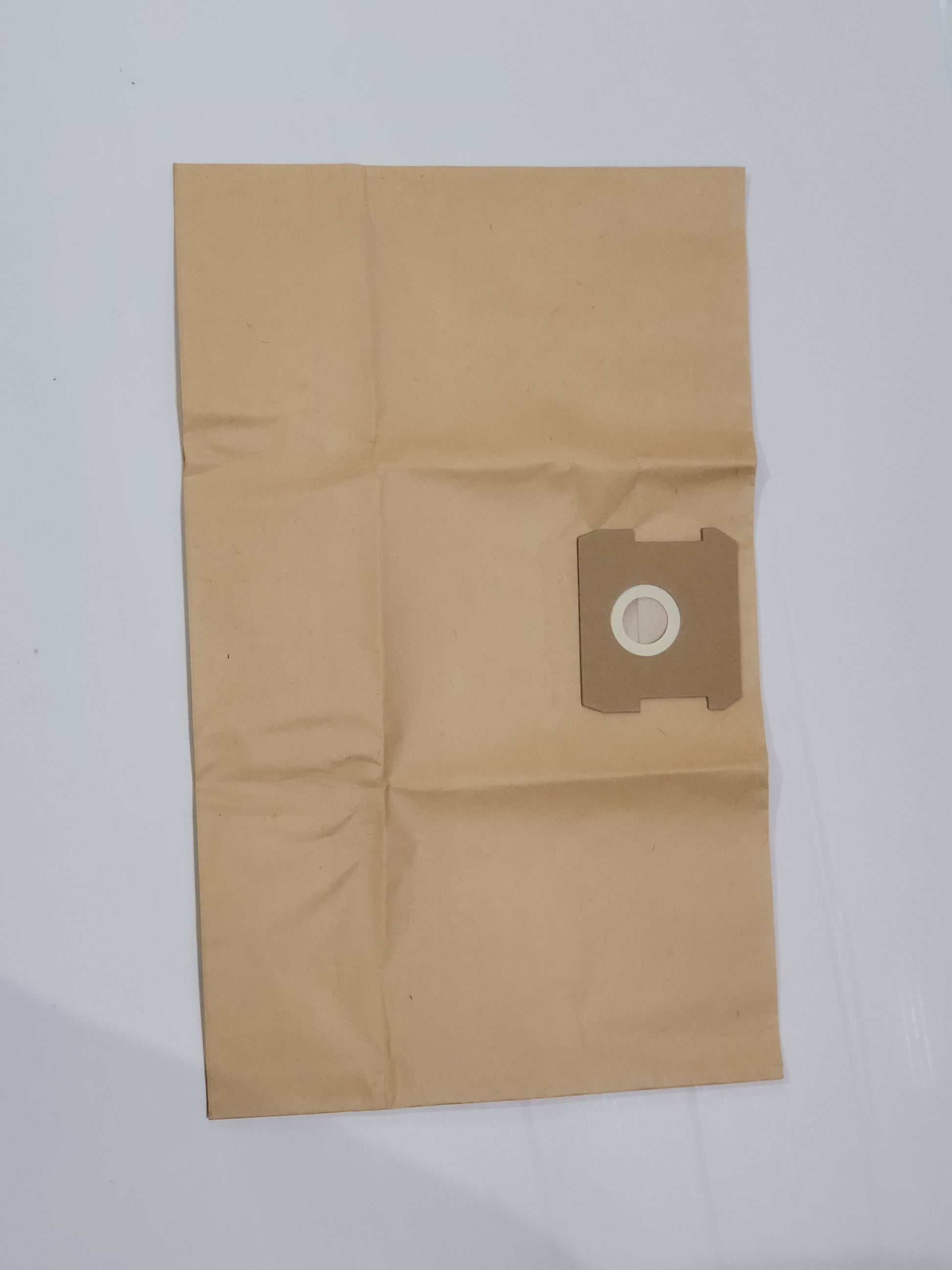 Ein brauner, mehrlagiger Papier Staubsaugerbeutel von immer-saugut für Parkside PNTSA 20 L und PNTSA 20 Li A1 liegt flach auf weißem Untergrund, mit kreisförmigem Kartonkragen und weißem Kunststoffring, leicht geknickt und ungefaltet.