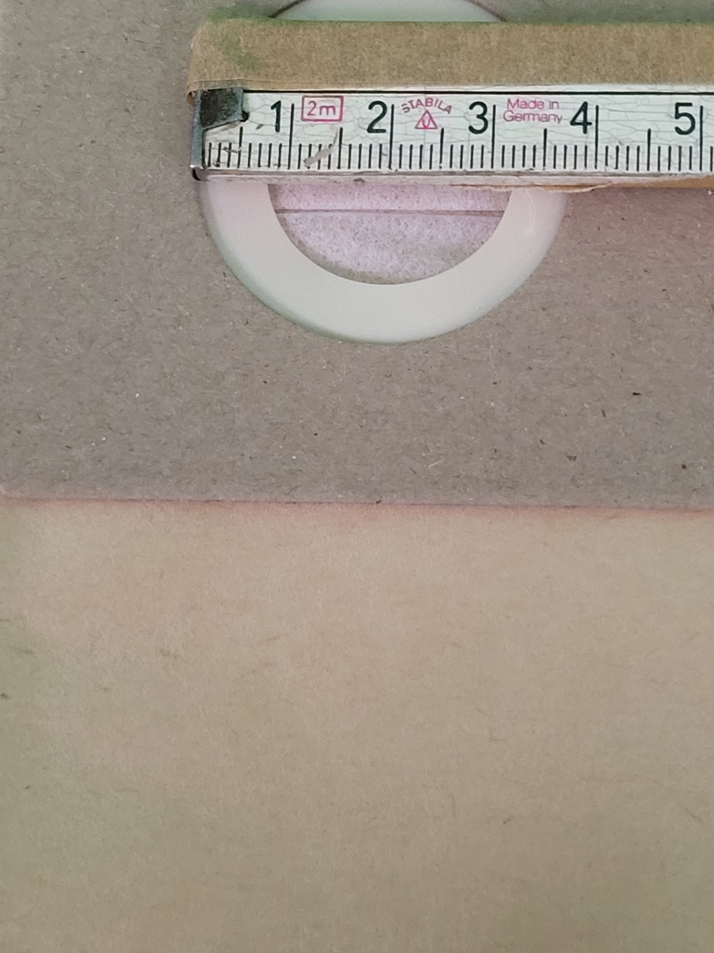 Eine Nahaufnahme zeigt einen weißen Ring, wahrscheinlich von einem immer-saugenden Staubsaugerbeutel (10er-Pack, für Parkside PNTSA 20 L/PNTSA 20 Li A1), teilweise unter Karton. Ein "Stabila"-Maßband zeigt an, dass der Außendurchmesser des Rings etwa 4 Zentimeter beträgt.
