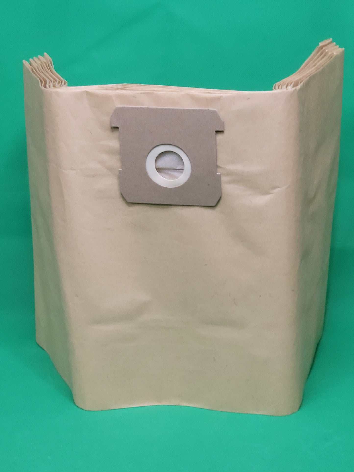 Ein großer beiger Staubsaugerbeutel von immer-saugut steht aufrecht auf Grün und zeigt seinen flachen Kragen und die runde weiße Öffnung. Der leere, gefaltete Beutel ist Teil eines 10er-Packs kompatibel mit Parkside PNTSA 20 L, PNTSA 20 Li A1 Staubsaugern.