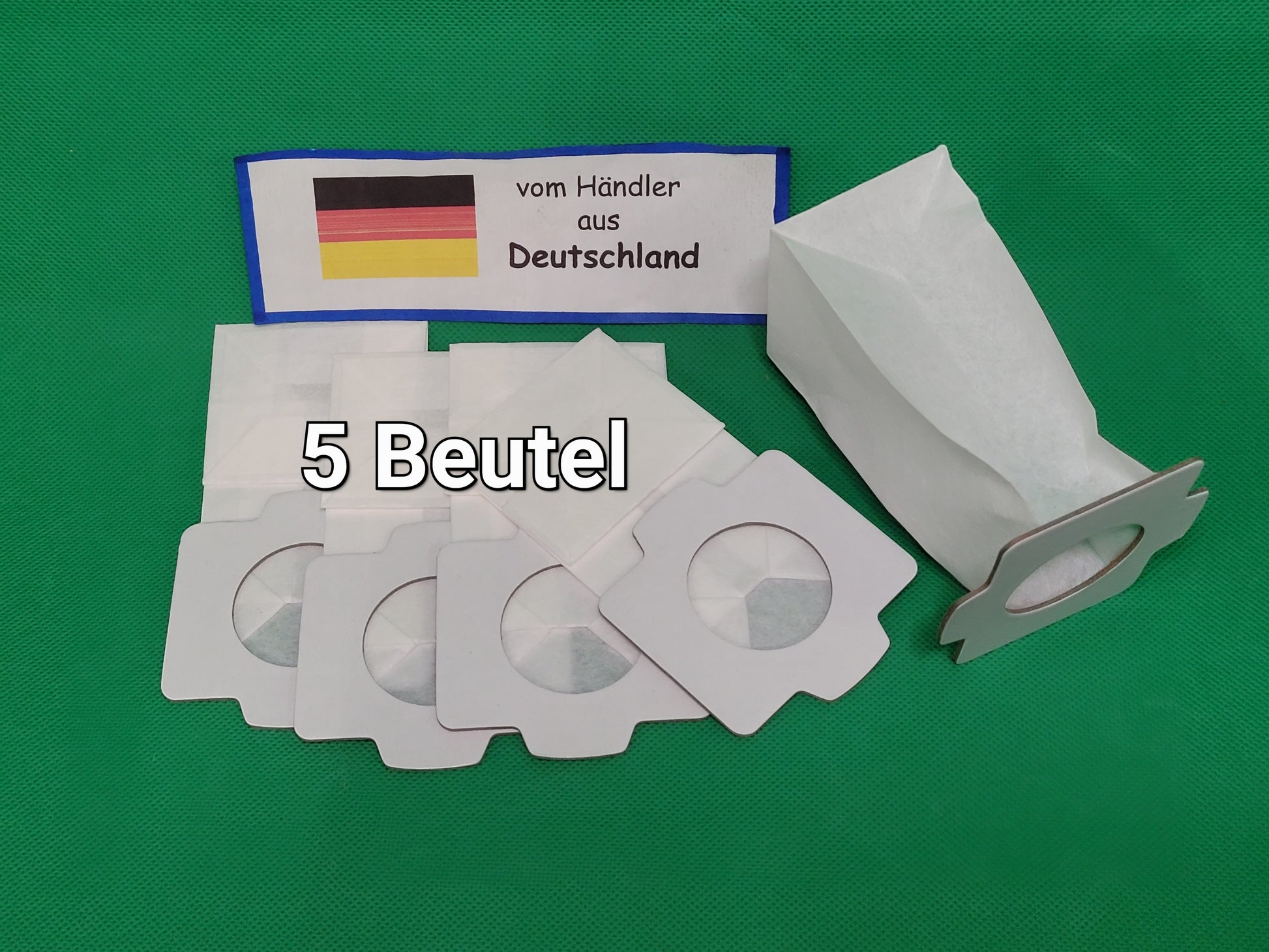 Fünf weiße immer-saugut Staubsaugerbeutel mit Kartonhalterung für Makita 194566-1, 198745-3 liegen auf grünem Untergrund. Ein Schild mit deutscher Flagge zeigt: "vom Händler aus Deutschland". Text: "5 Beutel".