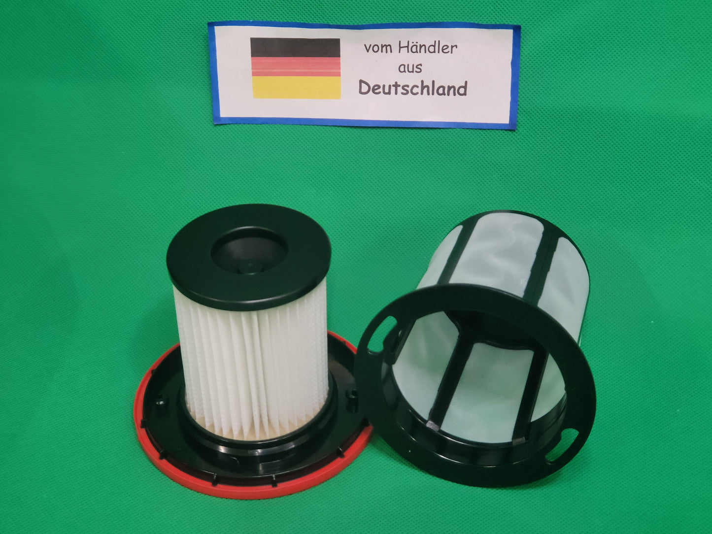 Zwei zylindrische ALMEc Supplies Filter (schwarzer und roter Sockel) kompatibel mit Bosch Serie 6, BCS6, BSS6, BKS6, BBS6, BLS6, 12033215 sind auf einer grünen Oberfläche mit einer deutschen Flagge Zeichen "vom Händler aus Deutschland".