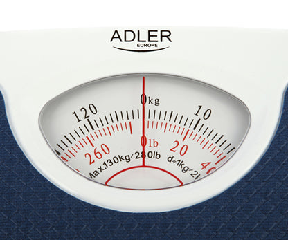 Die analoge Personenwaage AD 8151 in Blau der Adler Europe GmbH verfügt über ein weißes, rundes Zifferblatt mit schwarzen Markierungen für Kilogramm und roten Markierungen für Pfund sowie einen roten Zeiger, der auf der dunkelblauen, strukturierten Plattform auf Null zeigt.
