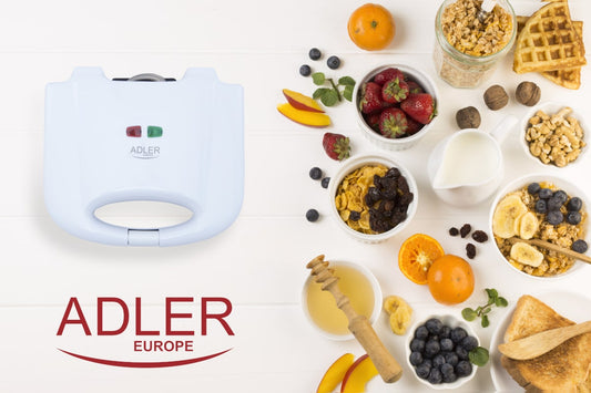 Ein weißes Immer-Saugut Adler - Waffeleisen mit antihaftbeschichteten Platten steht auf einer weißen Fläche neben verschiedenen Frühstücksartikeln. Dazu gehören Müslischalen, geschnittenes Obst, Erdbeeren, Milch, Honig, Nüsse, Waffeln und ein Glas Müsli. 