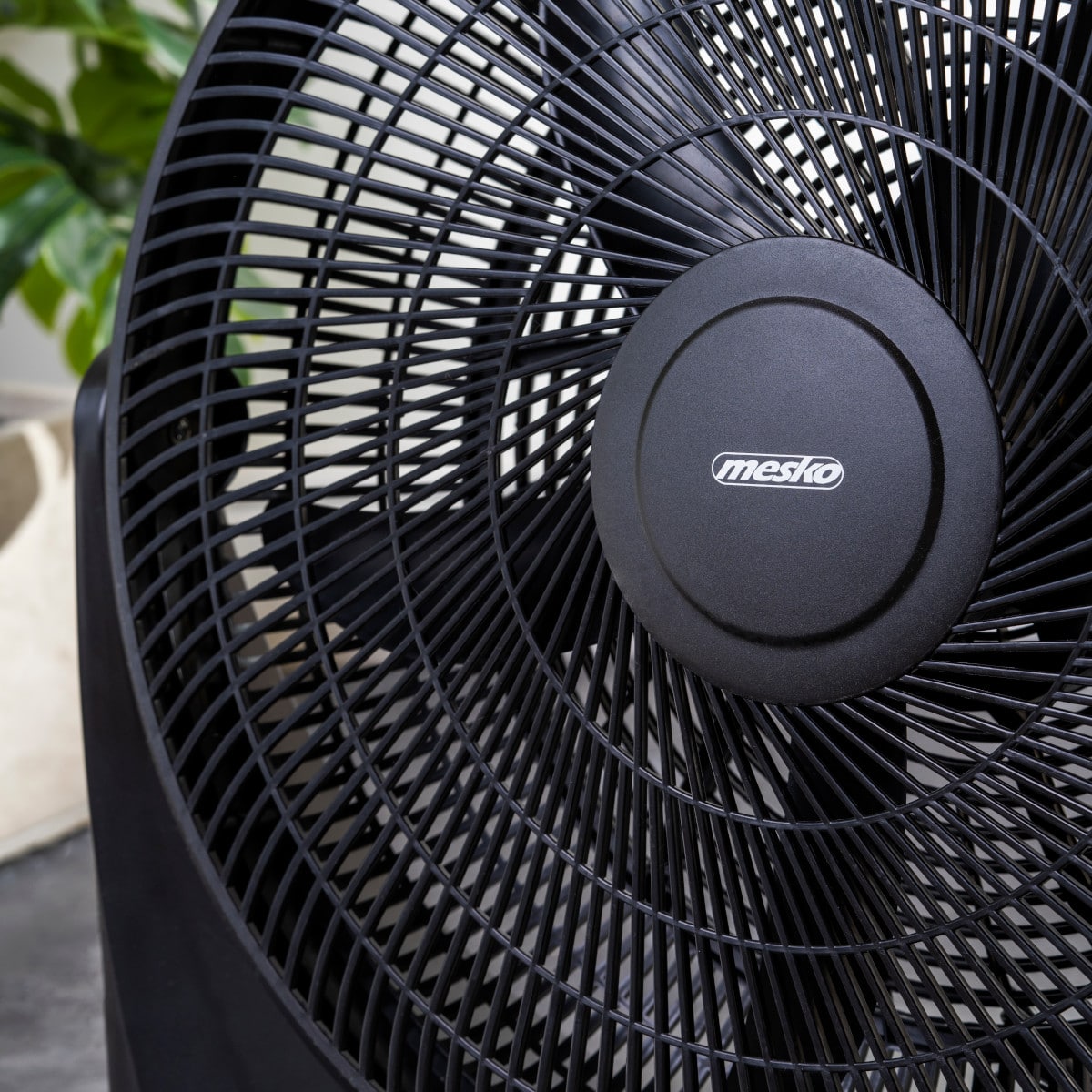 Nahaufnahme eines Mesko - Bodenventilators - 3 Leistungsstufen, XXL Rotor 50 cm, Neigungsfunktion mit robustem Motor und dem Markennamen &quot;immer-augut&quot; auf der zentralen Nabe. Die Flügel des Ventilators sind von einem kreisförmigen Gitter aus schwarzen Sch