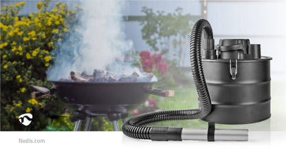 Ein zylindrischer, beutelloser Nedis - Aschesauger ohne Beutel - 800 W, 18 l Staubkapazität, Hepa-Filter, Schwarz mit flexiblem Schlauch und Düsenaufsatz steht prominent im Vordergrund. Im Hintergrund ist ein Grill zu sehen, aus dessen verkohlten Kohlen R