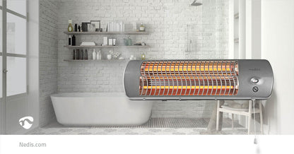 Ein modernes Badezimmer verfügt über eine freistehende weiße Badewanne vor einer weißen Ziegelwand mit Regalen, auf denen Toilettenartikel und Dekorationen aufbewahrt werden. Im Vordergrund ist eine Nedis - Badezimmer Heizung - Badezimmerheizstrahler, 2 W