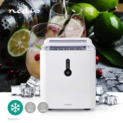 Ein weißer Eisbereiter von immer-saugut steht auf einer Theke, umgeben von Eiswürfeln, im Hintergrund ein Wasserkrug und Limettenfrüchte. Die Maschine mit einem 1,5-l-Wasserbehälter hat einen transparenten Deckel und ein digitales Bedienfeld. Unten links 
