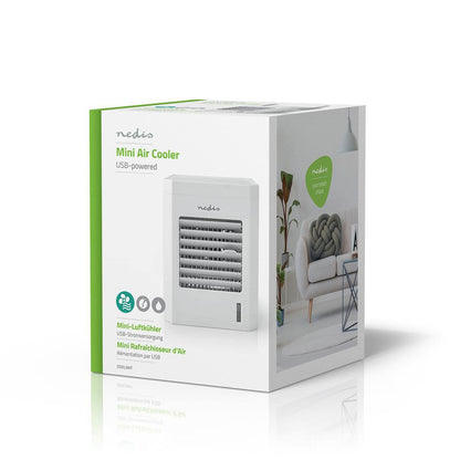 Das Bild zeigt ein verpacktes Immersaugut Nedis - Mini Luftkühler - Tischventilator mit Befeuchtung, USB-Anschluss, 56 m³/h, 51 dB. Die Verpackung ist hauptsächlich weiß und grün, mit einem Bild des Luftkühlers auf der Vorderseite. Das Produkt, auch als M