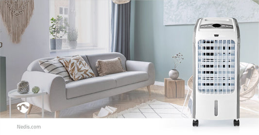 Ein modernes Wohnzimmer mit einem grauen Sofa, das mit gemusterten Kissen geschmückt ist, einem kleinen weißen Beistelltisch mit einer Pflanze und einem marineblauen, raumhohen Vorhang. Im Vordergrund steht ein Immersaugut Nedis - Mobiler Luftkühler mit F