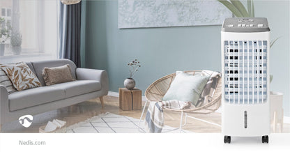 Ein stilvolles Wohnzimmer mit einem hellgrauen Sofa, das mit gemusterten Kissen geschmückt ist, einem runden Couchtisch aus Holz mit einer Vase und einem Korbstuhl, der mit einer gestreiften Decke drapiert ist. Auf der rechten Seite befindet sich ein ener