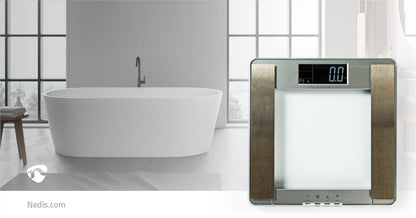 Ein modernes Badezimmer verfügt über eine freistehende weiße Badewanne vor einem großen Fenster mit Gitterfenstern. Im Vordergrund steht eine immersaugfähige Nedis-Personenwaage mit einem eleganten Metallrahmen und einer Körperfettanzeige, auf deren Bilds